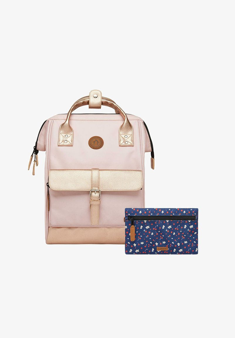 Rosa Rucksack mit metallic roségoldenen Akzenten und strukturiertem Frontklappe. Dazu gehört eine dunkelblaue Blumenzipper-Tasche, die daneben liegt.