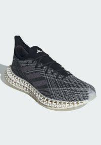 Black and gray athletic shoe with a textured upper, featuring a patterned knit design and a distinctive white lattice-style midsole.