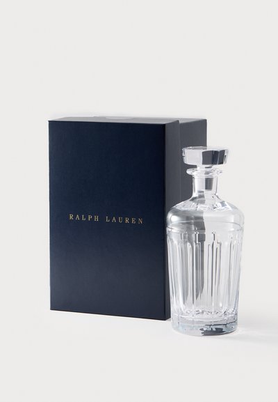 Klarer Glasdekanter mit vertikalen Schnittlinien, oben mit einem facettierten Stopfen, neben einer marineblauen Box mit der goldenen Aufschrift "RALPH LAUREN".