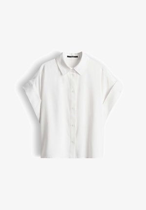 Chemise blanche à manches courtes avec col pointu et boutons, posée à plat sur un fond blanc.
