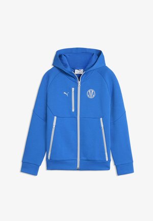 Felpa con cappuccio blu con cerniera, tre tasche con cerniera bianche, logo Puma e un emblema rotondo sul petto, mostrata su sfondo bianco.