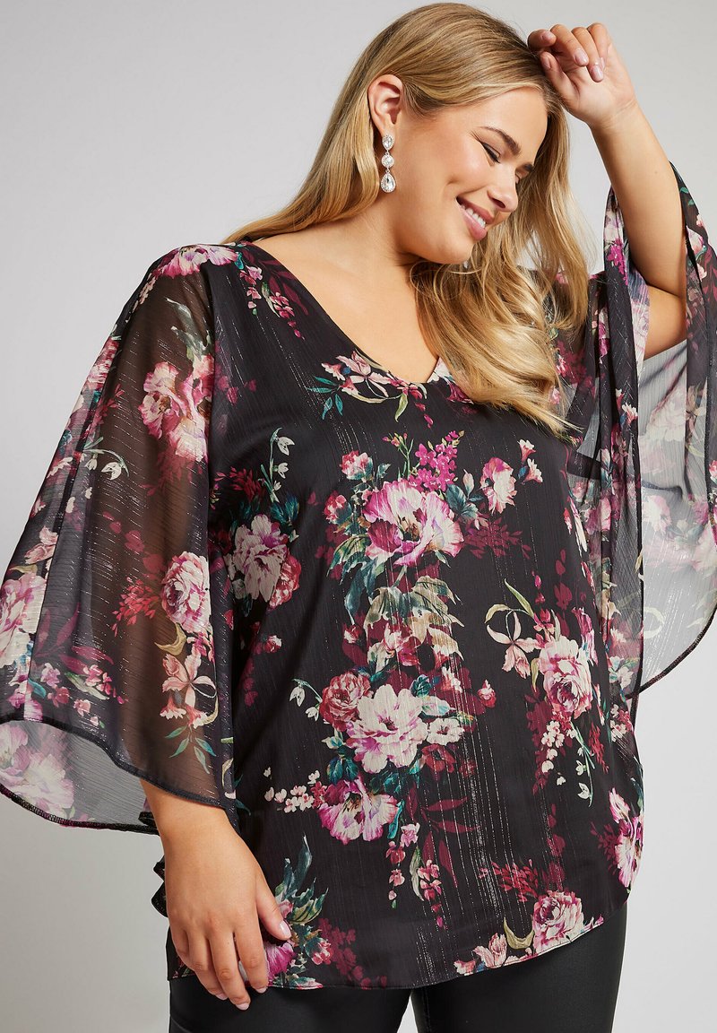 Top nero floreale con maniche a campana trasparenti. Decorato con fiori rosa e viola, presenta una scollatura a V e un design fluido. Tessuto morbido.