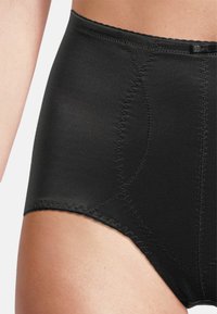 Hochgeschnittene schwarze Shapewear aus glattem Material, mit dezenten Nahtdetails und einem nahtlosen Abschluss an den Kanten.