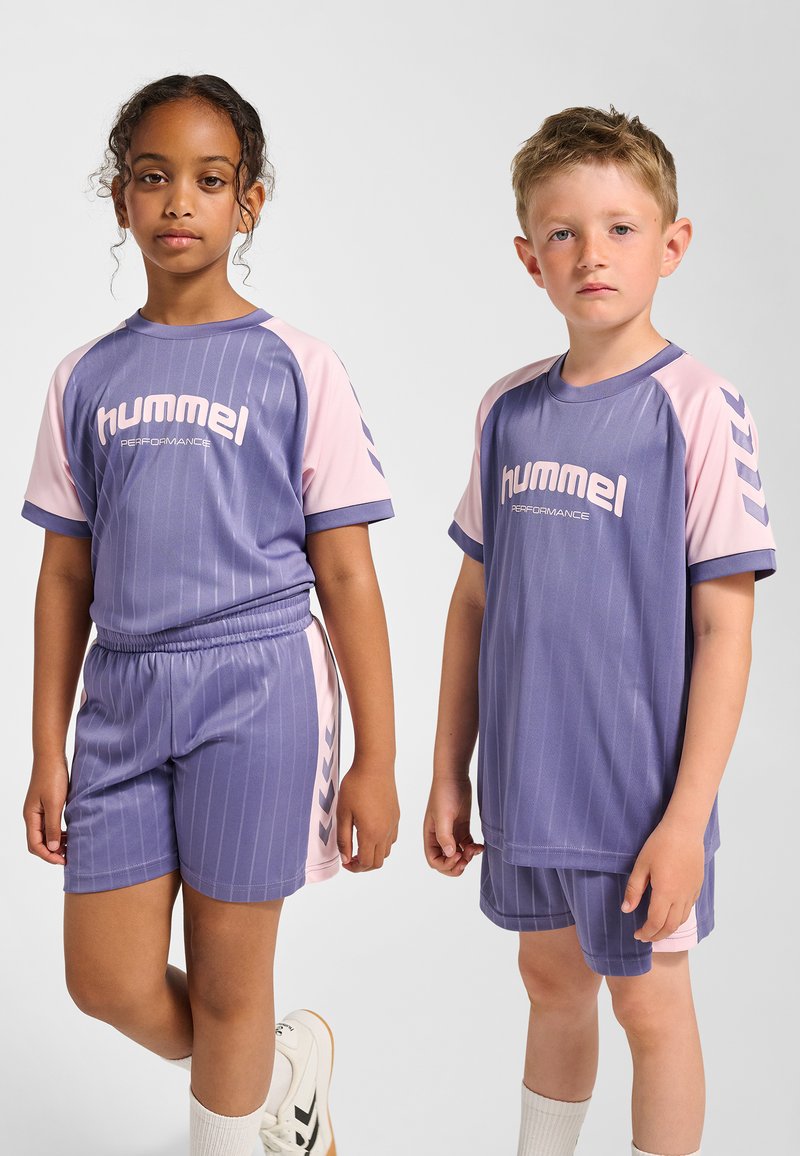 Lila sportset med kortärmad topp och shorts med ljusrosa accenter och vertikala ränder. Inkluderar "hummel"-logotyp på framsidan.