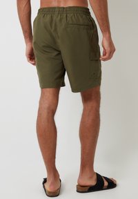 Zielone oliwkowe szorty typu cargo z elastycznym paskiem w talii, z tylnymi kieszeniami i jedną kieszenią z boku, wykonane z lekkiego materiału.