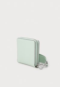 Mintgrön blixtlåsfodral med en slät yta, rektangulär form och silverdetaljer. Har en avtagbar rem för bekvämlighet.