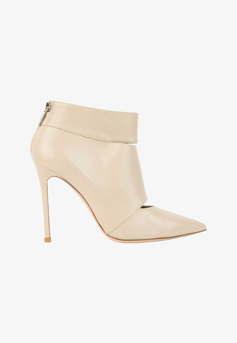 Bottine en cuir beige à talon haut, bout pointu et fermeture éclair au dos.