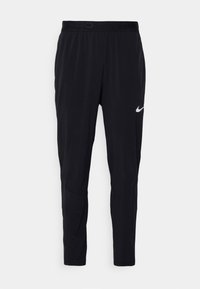 Černé sportovní kalhoty vyrobené z lehkého materiálu s elastickým pasem, s bílým logem Nike na dolní části levé nohavice.