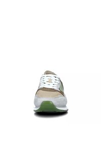 Sneaker beige e verde con superiore in rete, dettagli in suede, lacci bianchi, punta arrotondata e suola verde spessa.