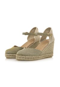 Espadrillas verdi con tomaia in tessuto intrecciato, cinturino alla caviglia e suola di corda rivestita in juta. Punta arrotondata e tacco testurizzato.