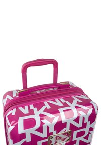 Maleta dura de color rosa con un acabado brillante, que presenta patrones de logotipos en blanco, dos cremalleras y un mango retráctil. Acentos en color dorado.