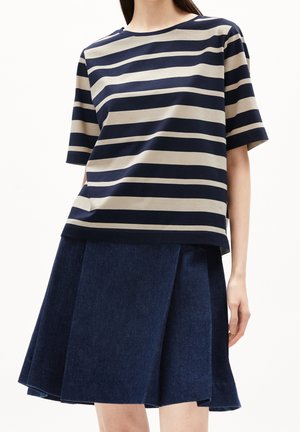 T-paita lyhyillä hihoilla, jossa on merivoimansiniset ja beige raidat, yhdistetty tummansiniseksi farkuhameeksi, jossa on laskoksia ja pehmeä rakenne.