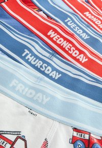 Ensemble de sept paires de boxers colorés avec des étiquettes de jour, arborant des couleurs de ceinture variées : rouge, bleu et bleu clair, ainsi qu'un design de camion de pompiers imprimé.