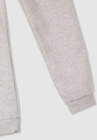 Jasnoszare dresy o miękkiej teksturze, zwężanym kroju, elastycznym pasie i ściągaczach na kostkach.