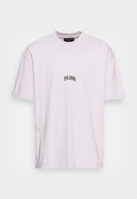 Svetle fialové tričko s krátkým rukávem, na kterém je uprostřed hrudi potištěný nápis "PEGADOR" malými černými písmeny.