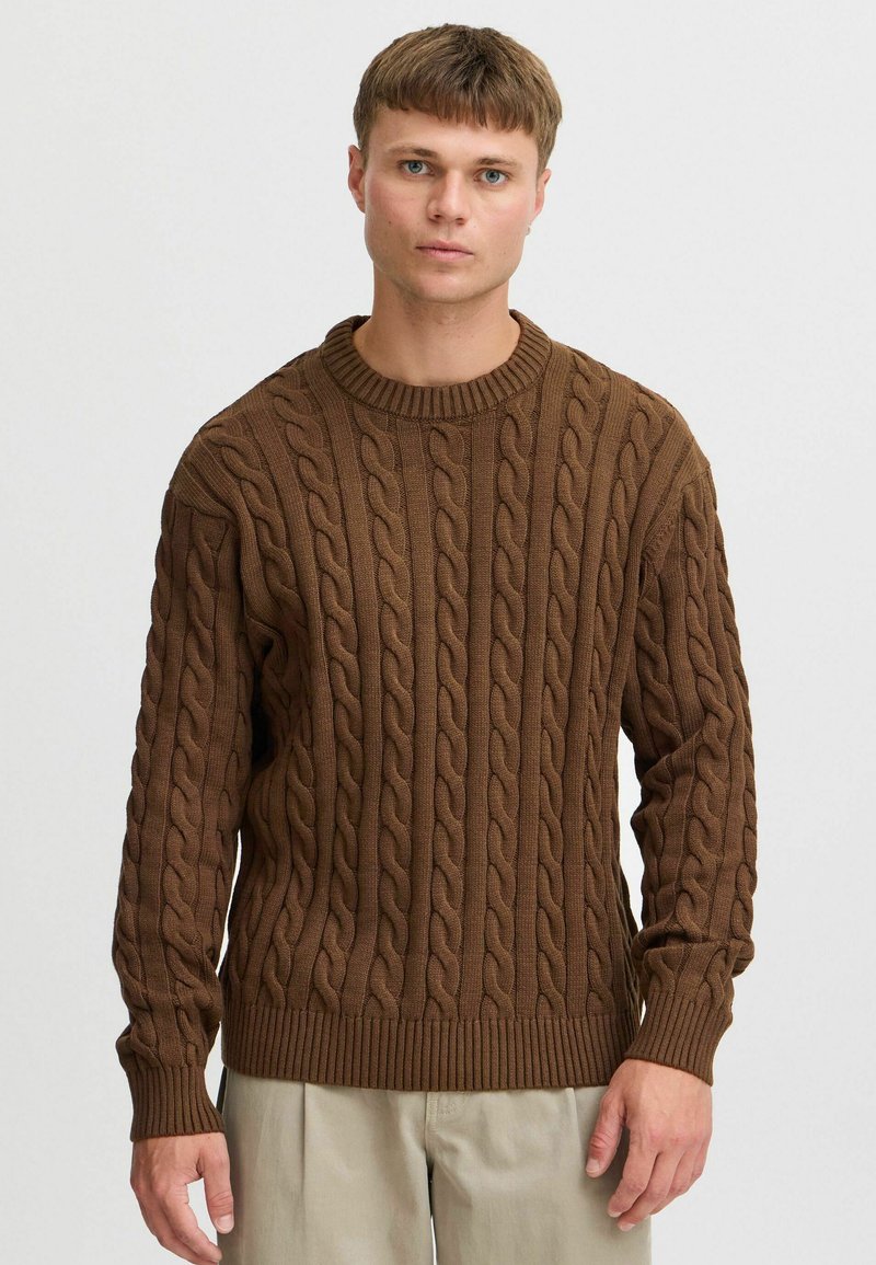 Brown cable-knit sweater with texture, crew neckline, and ribbed cuffs. Features a relaxed fit and distinctive raised patterns throughout.