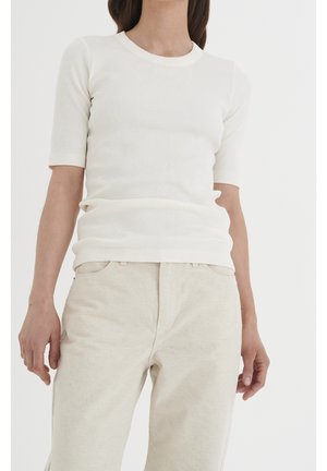 White ribbed short-sleeve top with a round neckline, paired with light beige wide-leg pants. Fabric appears soft with a textured finish.