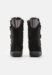 Svarta ankelboots med ett yttre i mocka och nylon, utrustade med en mjuk foder av päls, kardborreband och strukturerade gummisulor.
