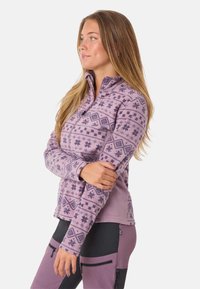 Fleece jacket met ritssluiting in lichtpaars met geometrische sneeuwvlokpatronen, lange mouwen en een hoge kraag. Ontworpen voor warmte en comfort.