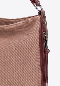 Borsa in tessuto rosa texturizzato con dettagli in pelle bordeaux, dotata di chiusura laterale con zip e tracolla rinforzata.