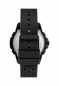 Orologio in gomma nera con cinturino spesso, fondello circolare in argento, manopola testurizzata sul lato e numerosi fori di regolazione sul cinturino.