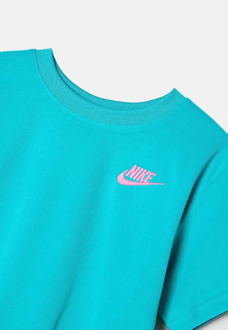 Türkises T-Shirt mit Rundhalsausschnitt, kurzen Ärmeln und kleinem pinkem Nike-Logo auf der linken Brustseite. Glatte Stoffstruktur.