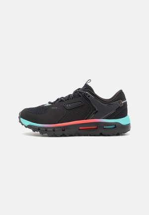 Chaussure de sport noire avec une tige en mesh et une semelle dégradée turquoise, rose et noire, avec un logo Under Armour sur le côté.