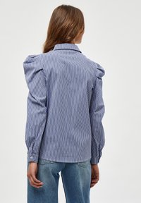 Blouse à rayures bleues et blanches, avec épaules bouffantes, manches longues à poignets boutonnés et col classique. Tissu léger.