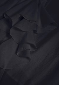 Tume sinine kangas pehme ja voolava tekstuuriga, kihilised ruffled ääred, sujuva viimistluse ja peene sädelusega.