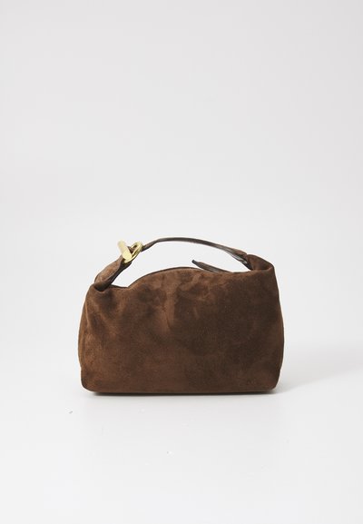 Brown suede handbag with a curved top, short strap, and gold hardware detail. Compact shape with a soft, textured exterior.