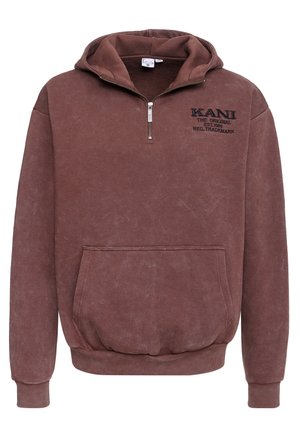 Brown half-zip hoodie with front kangaroo pocket and black embroidered text on left chest reading "KANI The Original Est.1989 Reg. Trademark."
