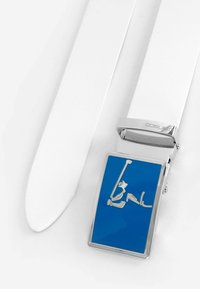 Weißer Leder Gürtel mit einer blauen rechteckigen Metallschnalle, die ein silbernes Figurendesign aufweist. Glatte Textur mit polierter Oberfläche.