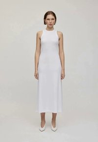 Vestido blanco sin mangas con un escote alto, corsé ajustado y falda fluida. Tela suave con una textura suave. Diseño simple, sin patrones.