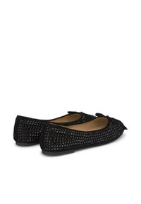 Ballerines noires en matériau doux, ornées de clous noirs, avec un bout rond et un petit nœud à l'avant.