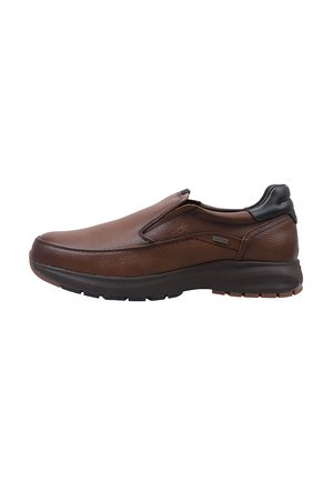 Zapatos marrones de tipo slip-on hechos de cuero texturizado con un acento negro liso en el talón. Cuentan con una suela de goma para mayor agarre y comodidad.