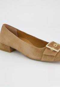 Chaussure plate en daim beige avec un accent de boucle carrée en or, talon bloc bas, intérieur lisse et design à bout arrondi.