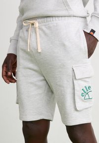 Harmaat puuvillasekoitteiset shortsit, joissa on nauhavyötärö, sivutaskut ja vihreä "elle"-logo brodeerattu cargo-taskussa. Sujuva pinta.
