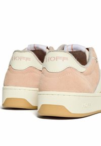 Sneaker in suede rosa con tallone in pelle bianca e suola bianca. Presenta dettagli del logo e una superficie texturizzata. Forma arrotondata con accenti morbidi.