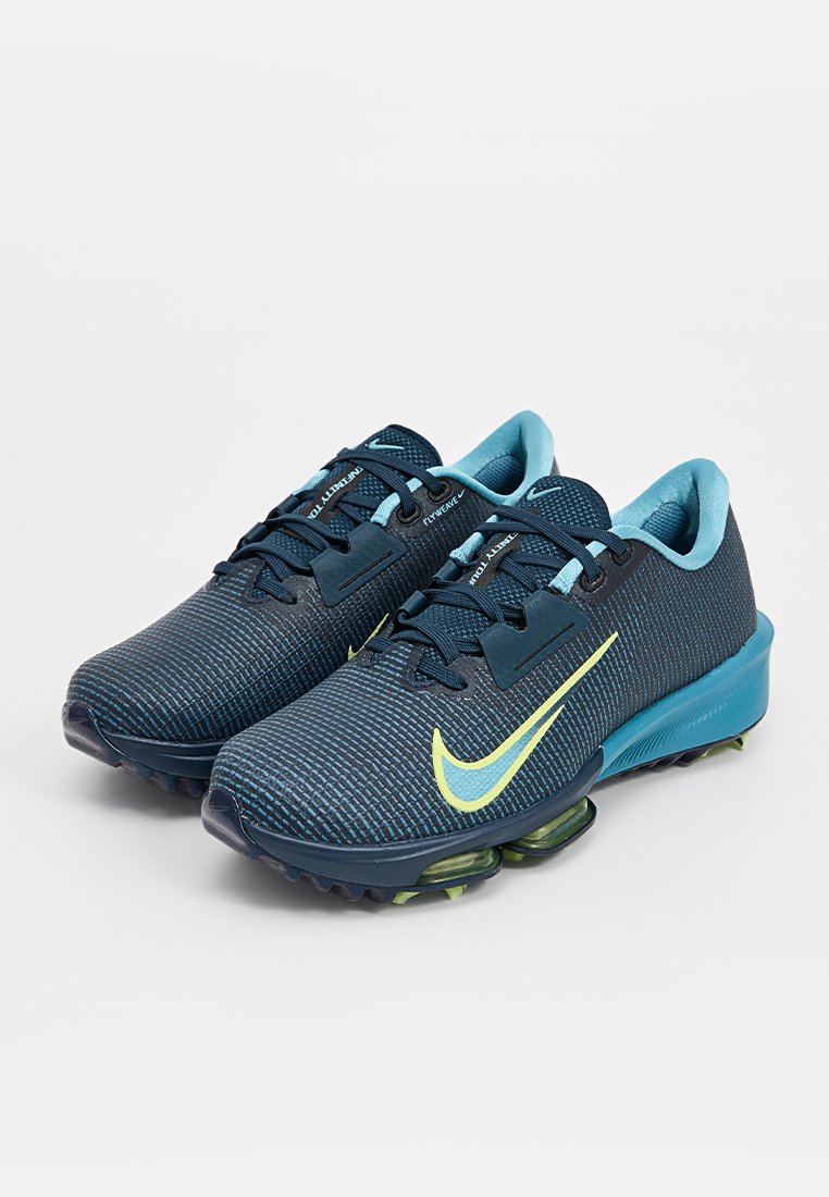 Nike hardloopschoenen met een donkerblauwe netstof bovenkant, lichtblauwe accenten, gele swoosh en een gevoerde zool met groene details.