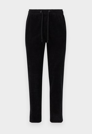 Black corduroy pants with an elastic waistband, adjustable drawstrings, and a tapered fit. The fabric has a vertical ribbed texture.