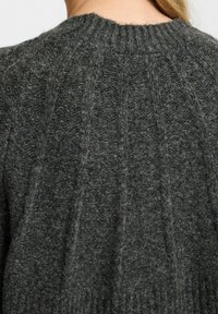 Dunkelgrauer gestrickter Pullover mit geripptem Ausschnitt, der vertikale Texturlinien auf der Rückseite aufweist, aus einem Woll-Mischmaterial gefertigt.