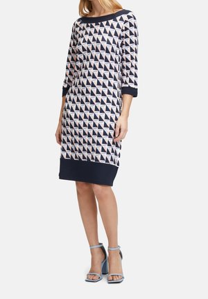 Jurk met patroon, driekwart mouwen, marineblauwe basis en roze geometrische driehoeken. Voorzien van een effen marineblauwe zoom en halslijn.