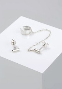 Silberne Ohrringe und Armreif mit minimalistischem Design. Verfügt über eine Kettenverbindung zwischen einem Stecker und zylindrischen Akzenten. Glatte Oberflächenstruktur.