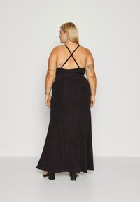 Black glitter maxi dress with a fitted bodice, crisscross straps, and a flowing skirt. Smooth texture, floor-length design, and subtle sparkle.