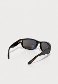 Ochelari de soare negri cu lentile întunecate, cadru din plastic slefuit, accente din metal auriu și detaliu cu logo pe braț. Formă ușor curbată.