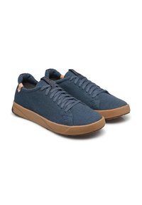 Sneakers in tela blu nautico con tomaia textured, punta tonda e suola in gomma marrone. Presentano lacci e un piccolo marchio laterale.