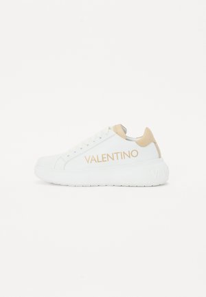 Basket en cuir blanc avec un accent beige au niveau du talon. Présente le logo "VALENTINO" en beige sur le côté, une semelle texturée et un design à bout rond.