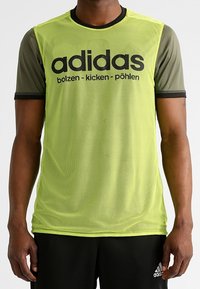 Zelené sportovní tričko z prodyšné síťoviny s krátkými rukávy, s černým logem a nápisem "adidas". Černé detaily na výstřihu a rukávech.