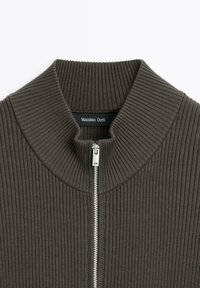 Maglione a coste grigio scuro con colletto alto e zip frontale. Presenta una texture liscia e l'etichetta del brand "Massimo Dutti" ben visibile.