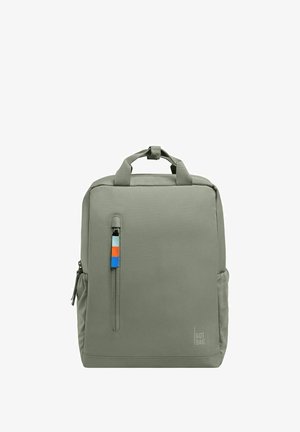 Grå stof rygsæk med en glat tekstur, frontlynlås lomme, lille farverig mærkat og top håndtag til at bære.